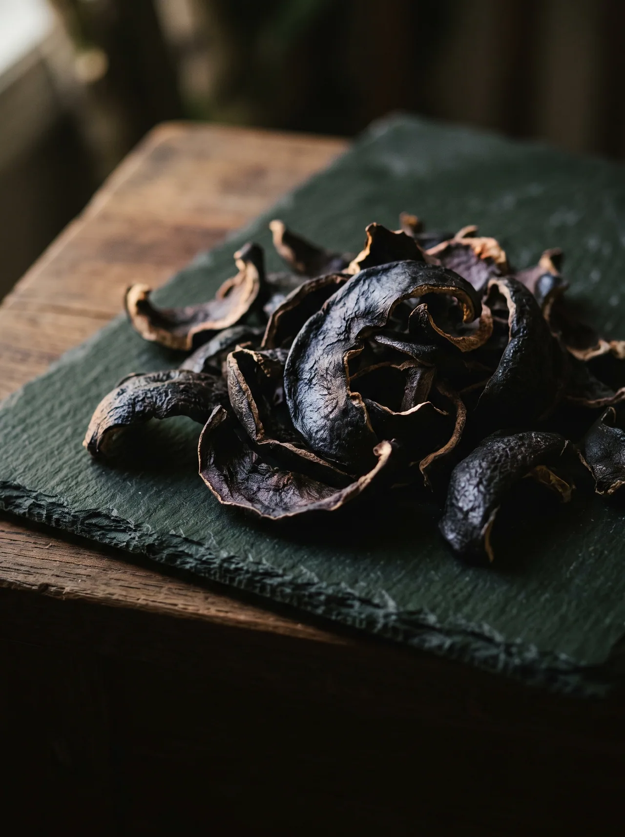 Dried garcinia rind piled on dark slate